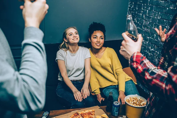 Schöne Aufnahme von Mädchen, die auf der schwarzen Couch sitzen und eine Performance genießen, die Jungen für sie gemacht haben. und Mädchen mögen es — Stockfoto