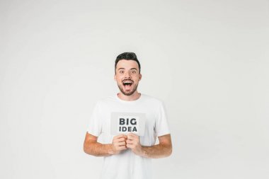 Güzel bir fotoğraf bir genç adam beyaz t-shirt beyaz odada ayakta ve büyük fikir bir yazıt gösteren ve gerçekten onda, sadece onun akla geldi.