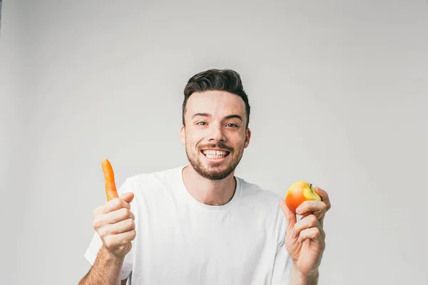Смішна і добра картина хлопця, який є вегетаріанцем і любить їсти хорошу їжу. Цього разу він вибрав моркву та яблуко. Він такий щасливий, що може почекати, щоб з'їсти цю їжу. крупним планом . — стокове фото