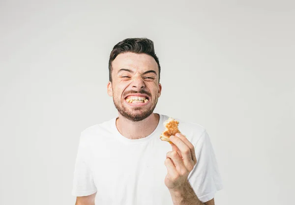 Una foto interesante de un hombre mostrando sus dientes llenos de pedazos de pan de hamburguesa. Él está tan feliz de comerlo que quería compartir esta felicidad con todos. Vista de corte . — Foto de Stock