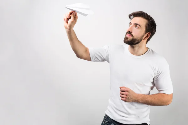 A picture from a different angle where the man in white shirt is ready to lauch his paper airplane. He can do it any second. Isolated on white background. — Stock Photo, Image