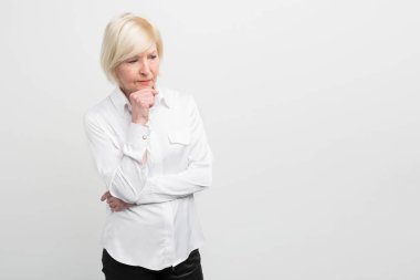 Üzgün ve yaşlı bir kadın hakkında bir şeyler düşünüyor. Bu görünüyordu bu yüzden hiç emin değil bu yüzden o sağlık ile ilgili bazı sorunların var. Görünüm kesti. Beyaz arka plan üzerinde izole.