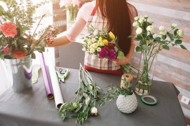 İşyerinde kadın çiçekçi: genç ve güzel esmer kadın moda modern buket farklı çiçek yapma. Çiçekli atölyesinde çalışan kadınlar