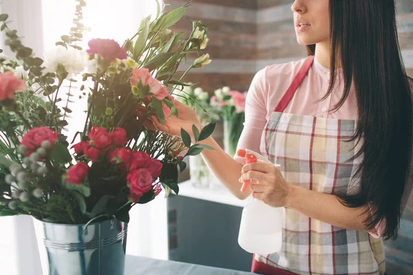İşyerinde kadın çiçekçi: genç ve güzel esmer kadın moda modern buket farklı çiçek yapma. Çiçekli atölyesinde çalışan kadınlar