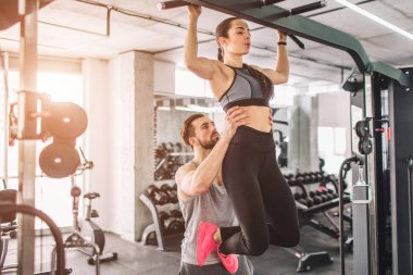 Eğitmen ve onun öğrencisi gy var. Onu yukarı çekmek için yardım ediyor. Bu büyük liste-in egzersizleri bir parçasıdır.