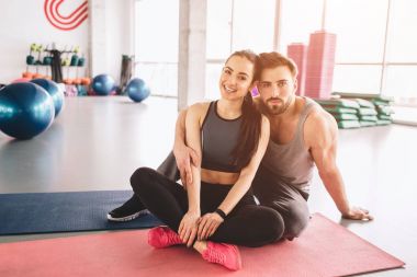 Güzel atış crossfit gibi iki millet. Onlar birlikte oturan ve kameraya poz. Adam ciddi görünüyor iken kız gülümsüyor.