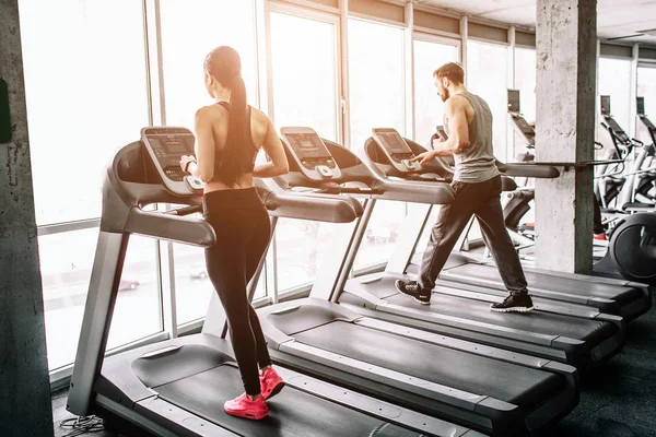 A kis kilátás nagy sport-szoba, ahol két ember van birtoklás edzés. Ők futás elliptikus gépek. A gyakorlat, kemény és intenzív. — Stock Fotó