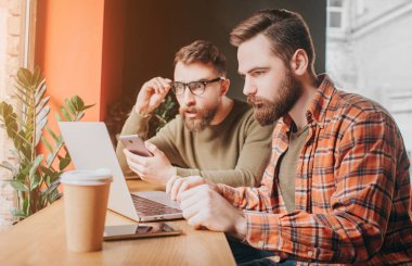 Şaşırdım ve üzgün genç erkekler için dizüstü ekran arıyoruz. Bir tanesi sağ eli ile gözlük tutan ve sol bir ile bir telefon tutarak.