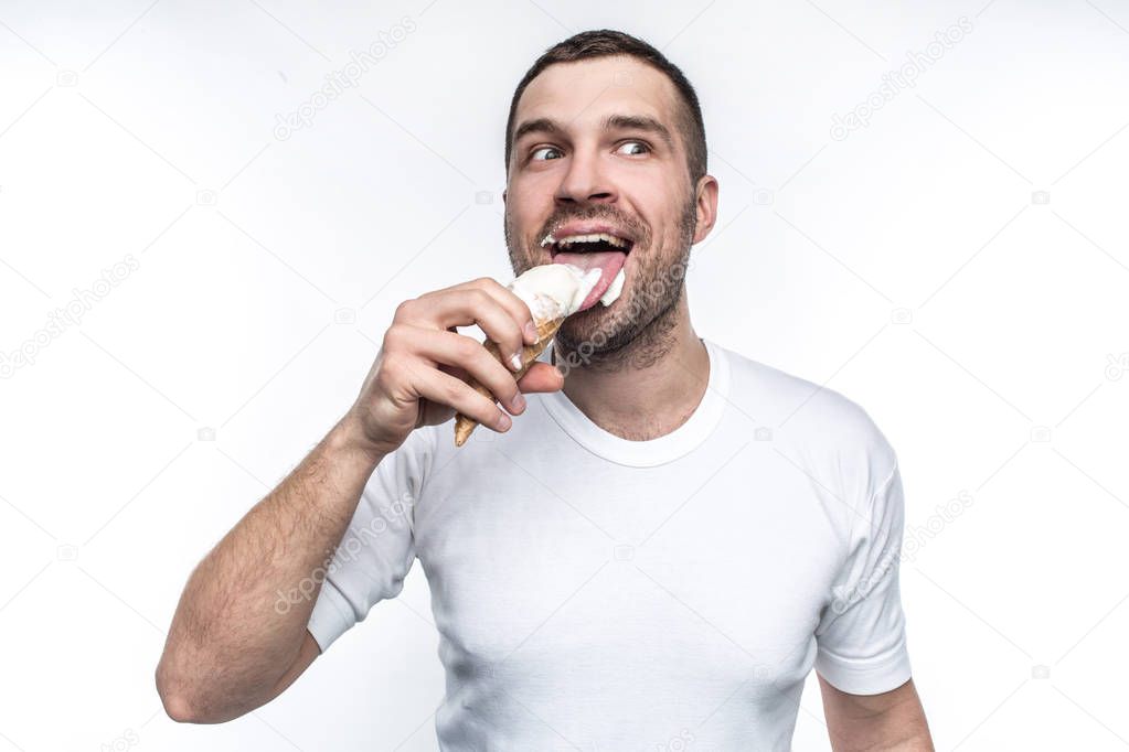 This big guy is like a small boy. He likes sweets and ice cream. He is liking a cone full of ice cream. Man is looking somewhere aside and enjoying the process of eating. Isolated on white background.