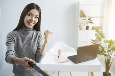 Live Stream masasına odanın köşesinde onun takipçileri için gösterilen kız. Ayrıca bir fincan ve orada defter ve laptop de vardır. O mutlu ve tüm dünyaya göstermek için gurur duyuyorum..