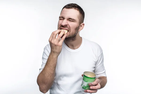 Een foto van jonge nd raar man eten chips uit de pot. Deze voeding is niet gezond en goed, maar hij houdt het. Hij is vol van vreugde wanneer hij junkfood eet. Geïsoleerd op witte achtergrond. — Stockfoto