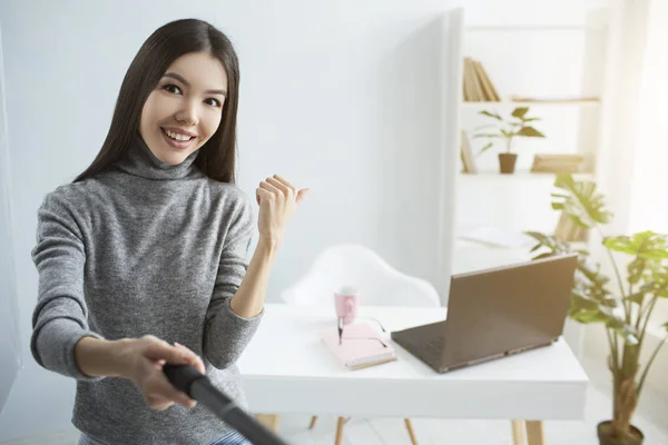 Live stream of girl showing her table in the corner of the room to her followers. Also there are a cup and a notebook there and laptop as well. She is happy and proud to show it to the whole world. — Stock Photo, Image