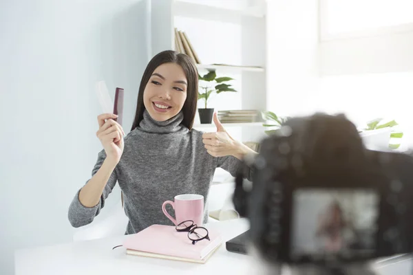 Beauty blogger is showing her hair brushes ckean and in good condition. She is looking at them and showing big thumb up. Camera is recording everything. — Stock Photo, Image