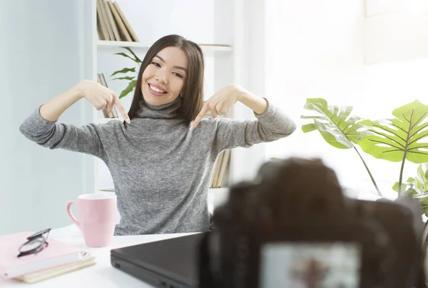 Fata fericită și încântătoare arată golful pe golful ei și zâmbește camerei. Ea înregistrează un nou vlog pentru canalul ei . — Fotografie, imagine de stoc