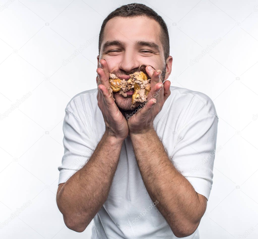 Closer shot of guy that has put too manu eclaires in his mouth. It is full right not and man cant chew it. He tries to keep eclaires in his mouth. Isolated on white background.