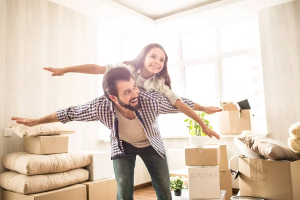 Bonita y hermosa foto de padre e hija pasando tiempo juntos. La chica está acostada sobre sus papás y fingiendo que está volando. Su padre está haciendo lo mismo. Ambos son felices. . — Foto de Stock