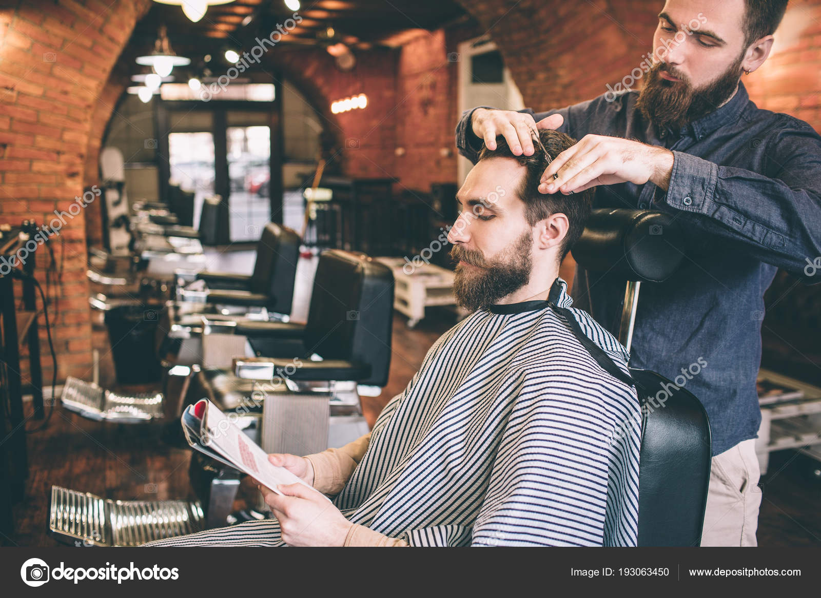 The Customer Is Sitting In Chair And Reading Magazine While The