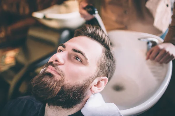 Großaufnahme des Kopfes von Kunden, der vom Friseur gewaschen wird. Er wäscht sie mit Wasser. Verfahren ist sanft und pflegeleicht. — Stockfoto