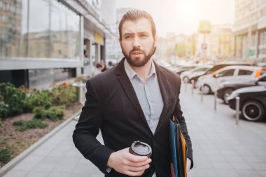 Meşgul bir adam acelesi var, o zaman yok, üstünde belgili tanımlık gitmek telefonda konuşacak. İşadamı arabanın kaputu üzerine birden fazla görev yapıyor. Çoklu görev iş kişi kahve içiyor