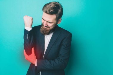 Adam sağ taraftan dirsek içinde acı çekiyor. O dirsek holding ve bakınca. Adam acı çekiyor. Ağrı nokta kırmızı ışık ile işaretlenir. Üzerinde mavi arka plan izole.