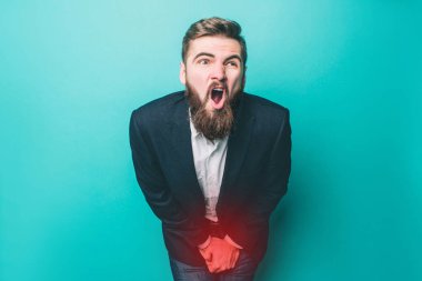 Adam üretra acı acı. O bu yüzden çığlık ve vücuttaki ağrılı yere elleriyle kapsayan. Üzerinde mavi arka plan izole.