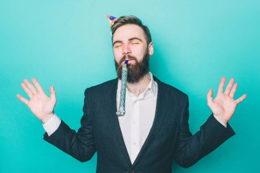 Mutlu bir adam ayakta ve an tadını. Onun kafasını ve dudakları ile Efes holding doğum günü şapkası var. Ayrıca adam ellerini gösteriyor. Üzerinde mavi arka plan izole.