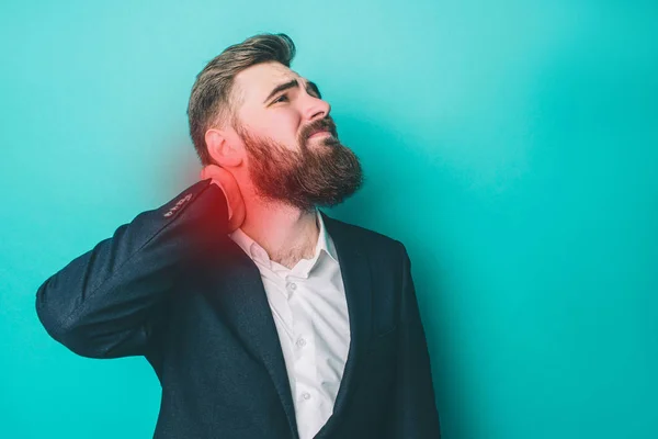 En bild av mannen som har en smärta i nacken. Smärta är markerad med rött ljus. Kille lider av den. Isolerad på blå bakgrund. — Stockfoto