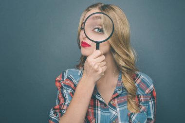 Genç kadın bir büyüteç tutarak ve direk orada arıyor. O çok ciddi bir durum. Üzerinde mavi arka plan izole.