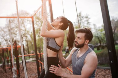 Güçlü kız kadar çatıya çıkarken ve de arıyor. Onu antrenman ör holeping olduğunu onun dengesini korumak için. Onu destekliyor.