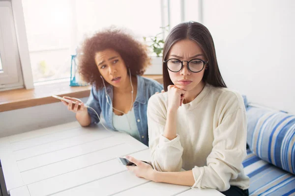 Ein Bild eines aufgebrachten Mädchens im weißen Pullover. Sie hat sich von ihrem Freund abgewendet. Afroamerikanisches Mädchen versucht mit ihrem Freund zu sprechen. — Stockfoto