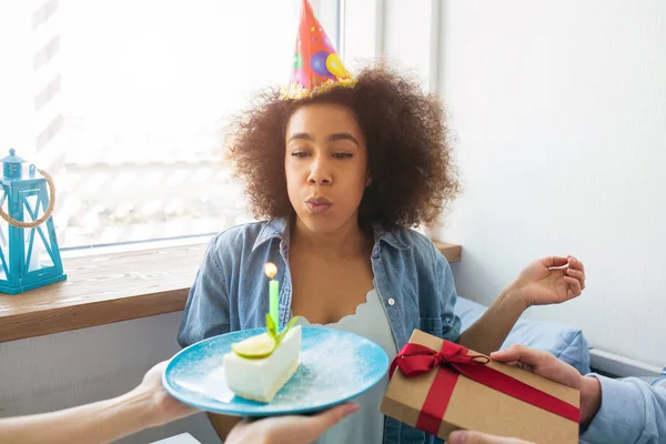 Ein Bild von Geburtstagskind, das die Kerze in die Luft sprengt und ein Geschenk von ihren Freunden bekommt. — Stockfoto