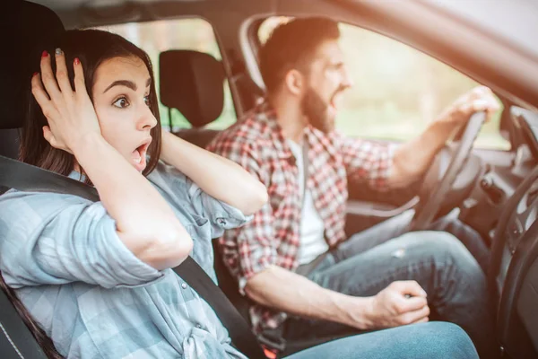 Un gars fou et une fille étonnée s'arrêtent de façon inattendue. Guy crie tandis que la fille tient ses mains près des oreilles et regarde sur la route . — Photo