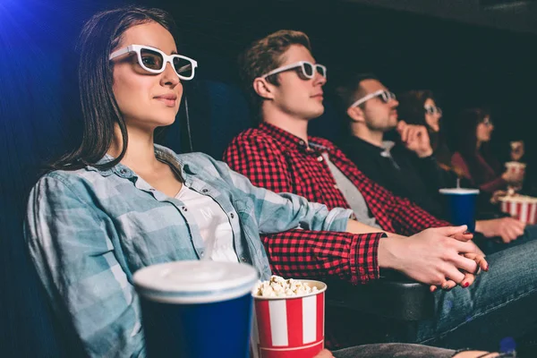 Calm and relaxed students are watching movie. They are sitting together in one row. People are very happy. — Stock Photo, Image