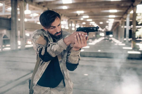 Uma foto de um soldado bonito e profissional apontando. Ele está fazendo isso olhando para a frente. Ele está a usar a pistola para isso. O tipo é muito cuidadoso. . — Fotografia de Stock