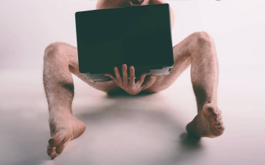 Genç çıplak adam porno izliyor ve mastürbasyon yapıyor.