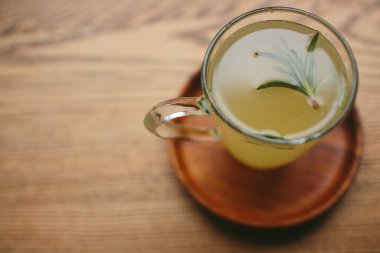 Zencefilli çay. Bardakta sıcak bir içecek, ahşap bir masa, üst manzara.