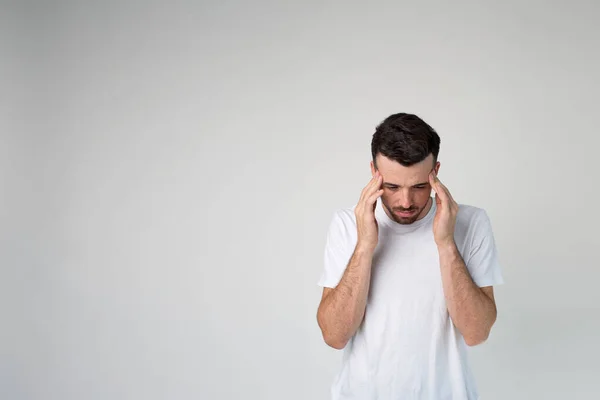 Jovem isolado sobre o fundo. Dor de cabeça ou pensamento. Calma cara pacífica no estúdio ficar sozinho e olhar para baixo . — Fotografia de Stock