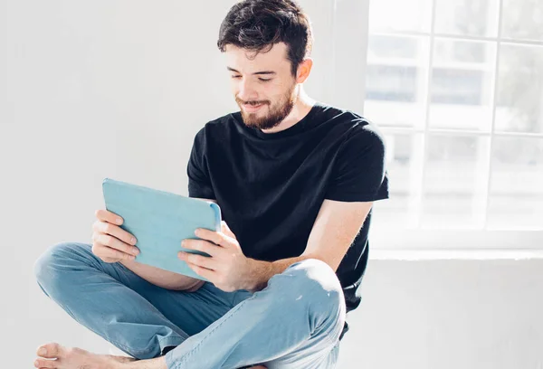 Man is played on the tablet. Student resting on campus — Stock Photo, Image