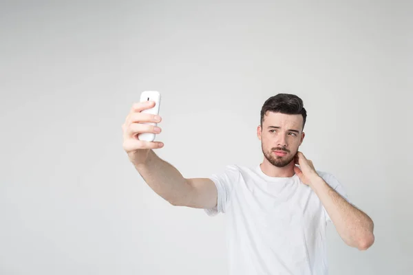 Young man isolated over background. Take selfie using smartphone in his hand. Stand alone and pose. Modern technologies. Super device in his hands. — Stock Photo, Image