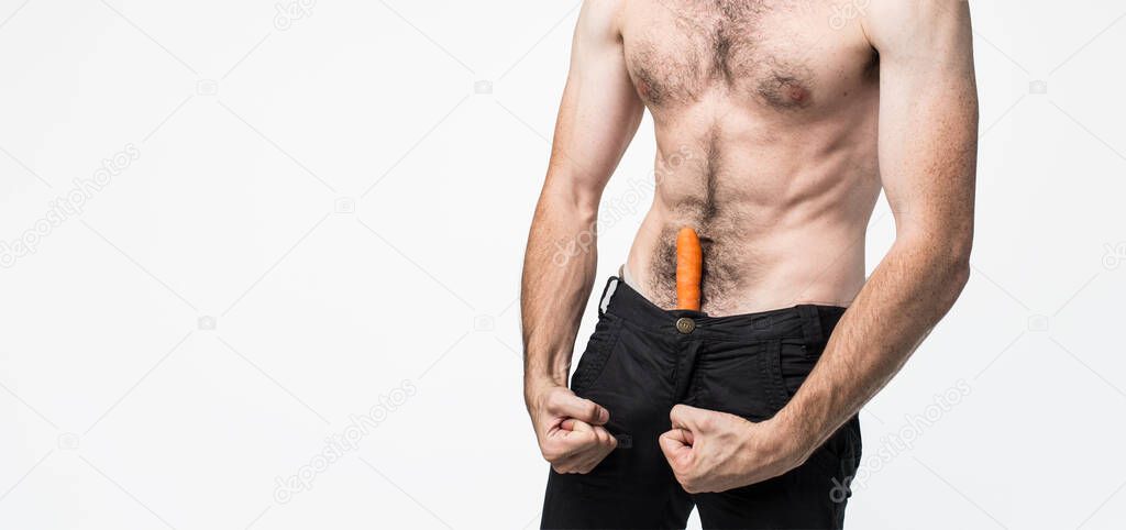 Young man isolated over background. Picture of guy has carrot in his pants and show he is sexual and powerful. Well-built strong body. Pale skin.