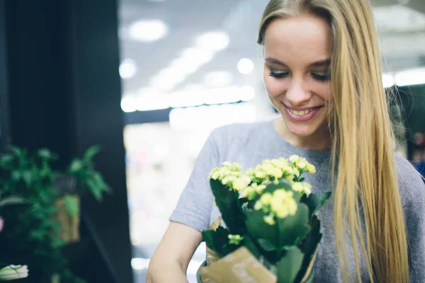 Mujer joven comprando flores en un centro de jardín — Foto de Stock