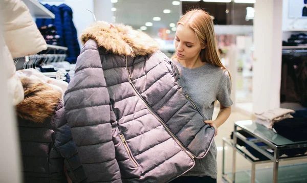 Die schöne Blondine kauft neue Sachen in einem Bekleidungsgeschäft. Verkäuferin arbeitet in Boutique — Stockfoto