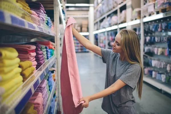 Krásná žena prohlížení a nákup ručníky v supermarketu. — Stock fotografie