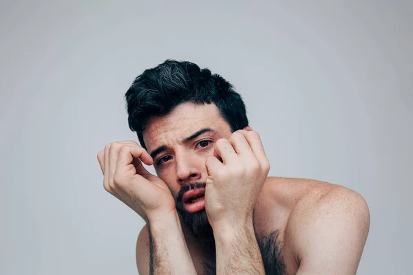 Giovane uomo isolato su sfondo. Stanco ragazzo stressante posa sulla macchina fotografica. Tieni le mani vicino al viso. Espressione facciale. Confuso uomo interessato in foto . — Foto Stock