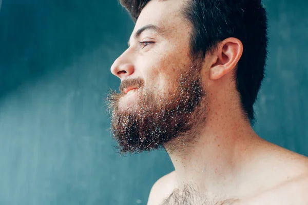 Young man isolated over blue background. Side view of bearded guy look to left. Shirtless man stand alone. Pale skin. — Stock Photo, Image