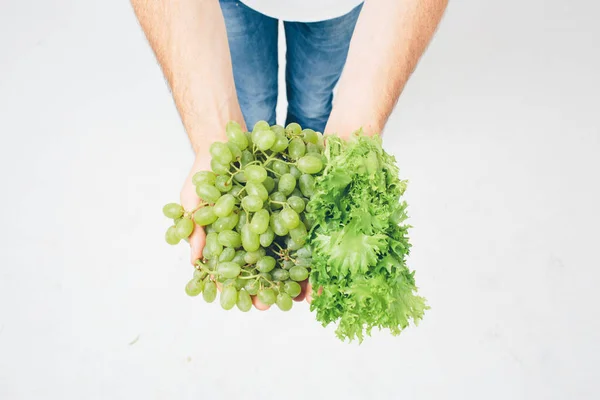 Человек с салатами и виноградом, закрывайте. концепция. изолированные на белом — стоковое фото
