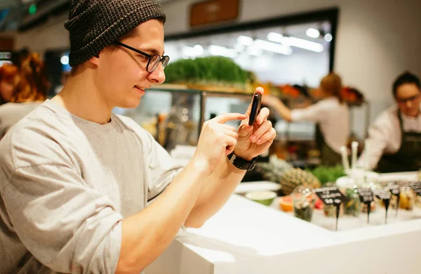 Alışveriş merkezinin arka planında akıllı telefonu tut. — Stok fotoğraf