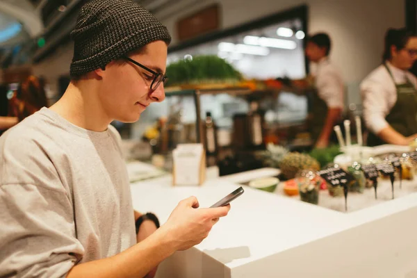 Alışveriş merkezinin arka planında akıllı telefonu tut. — Stok fotoğraf