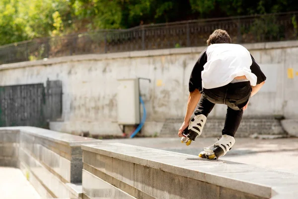 Visão traseira do jovem patinador profissional fazendo acrobacias fora. Vista urbana moderna. Patinar numa perna. Outítida à luz do dia . — Fotografia de Stock