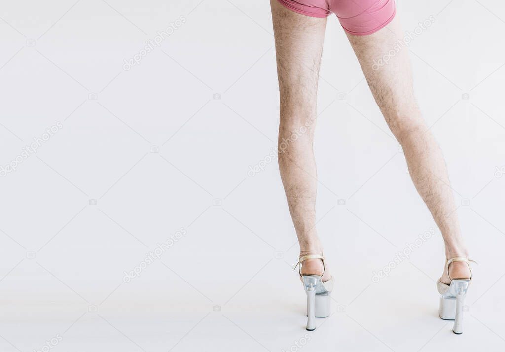 Hairy legs in high heels in pink panties isolated on white background